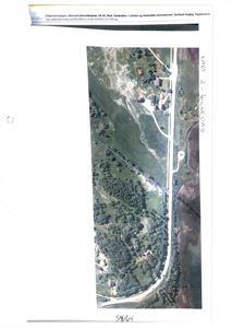 Flyfoto eller kartutsnitt som viser tomt, vegnett og eksisterende bygninger i et naturområde.