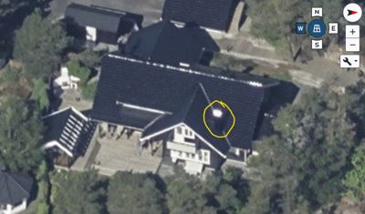 Satellittbilde (flyfoto) av en bygning sett fra luften, med en markering på taket.
