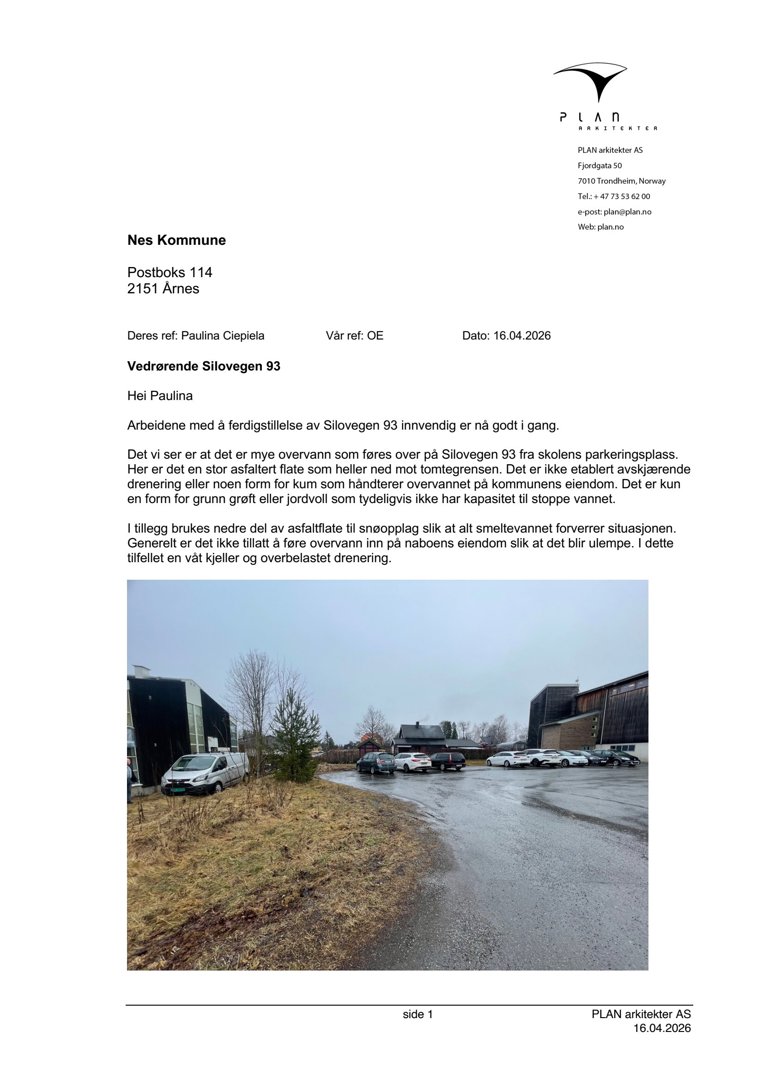 Fotografi av en asfaltert flate (parkeringsplass) som er overvannet, med bil og bygninger i bakgrunnen.