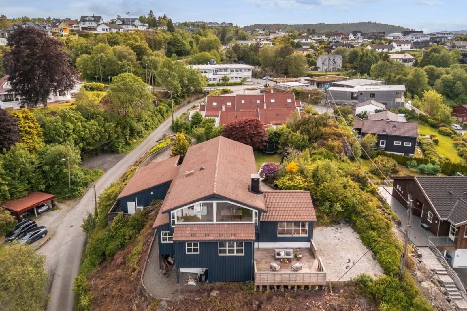 Luftfoto av en bolig og omgivelser, inkludert nabolag og topografi.