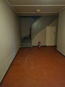 Fotografi av en trapp og en dør i en bygning, sannsynligvis et gangområde eller etasjeskift.