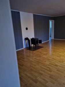 Fotografi av et tomt rom med gulv, vegger og en peis.