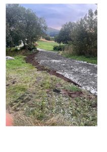 Fotografi av en vei eller kjøreflate under anleggsarbeid, med grus og utgravde kanter.