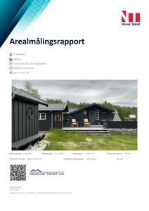 Fotografi av en mørk frittstående hytte med en terrasse og en mindre tilhørende bygning (anneks) i bakgrunnen.