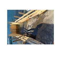 Fotografi av en konstruksjon med trebjelker og stolper i vann, sannsynligvis en kai eller brygge under bygging.