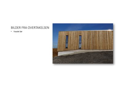 Fotografi av bygningens sørfasade med trepanel og vinduer.