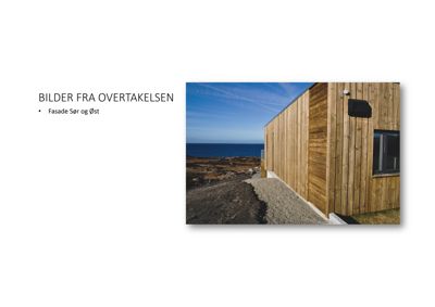 Fotografi av en bygning med trefasade mot havet, tatt under overtagelsen.