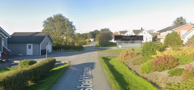 Fotografi av en eksisterende boligbebyggelse med en vei i forgrunnen. En tegning er overlagt på bildet.