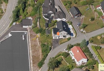 Satellittbilde (flyfoto) av et boligområde med vei, tomter og hus.