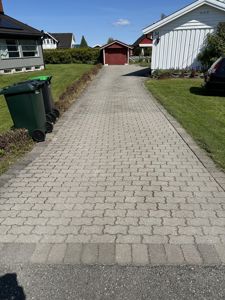 Fotografi av en befestet vei/garasjevei i et boligområde.