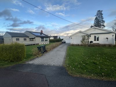 Fotografi av to hus i en boligstrøk med en sti mellom dem.