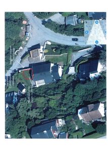 Luftfoto av et boligområde med overlagte tekstmeldinger som peker på spesifikke bygg og planer.