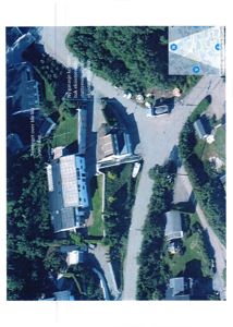 Luftfoto av et eksisterende bygg og omgivelsene, med annotasjoner om planlagte endringer.