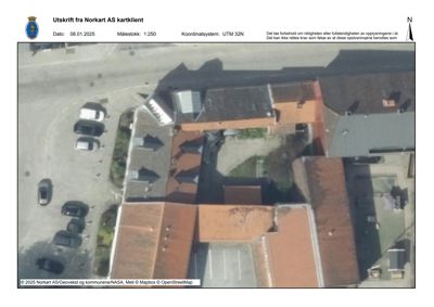 Flyfoto eller kartutsnitt som viser tomt, bygninger og veier sett fra lufta.