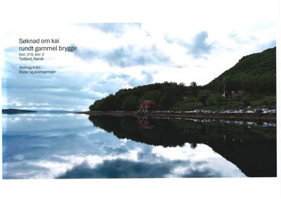 Fotografi av eksisterende bygning (rødt hus) ved kystlinjen i Tysfjord, som er en del av søknaden om kai.