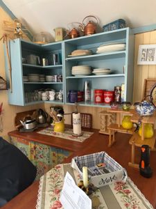 Fotografi av en innredet kjøkkenrom med blått skap og bord.