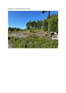 Fotografi av en tomt med fjernet container og vegetasjon.
