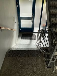 Fotografi av en trapp og inngangsdør i en bygning