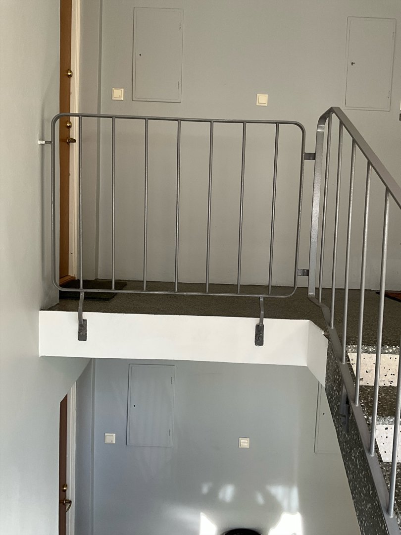 Fotografi av en trappeoppgang med metallrailing og en overgang til et annet nivå.