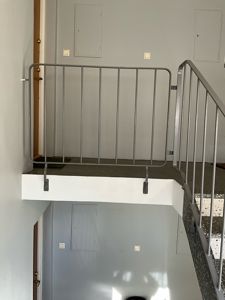 Fotografi av en trappeoppgang med metallrailing og en overgang til et annet nivå.