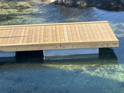 Fotografi av en ferdigbygd treplattform eller kai som står i vannet.