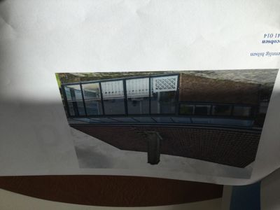 Fotografi av en nybygd eller ombygd fasade med store glassflater og en moderne utforming.