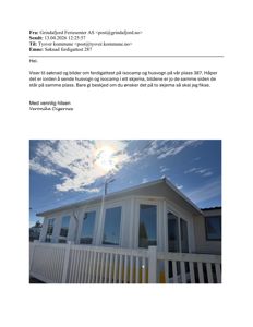 Fotografi av en hvit isocamp med store vinduer og en hvit veranda, sett fra en vinkel som viser fasaden og taklinjen.