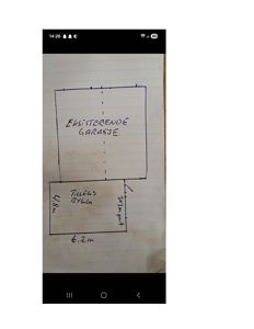 Håndtegnet situasjonsplan som viser en eksisterende garasje og en planlagt tilbygg med angitte mål.