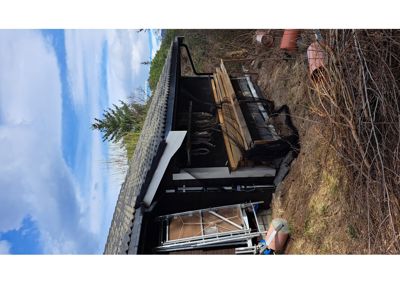 Fotografi av en bygning under utbygging eller vedlikehold, med synlig tak, fasade og omgivelser.