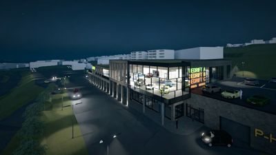 3D-visualisering av en planlagt bygning (bilforretning) sett fra utsiden om natten.