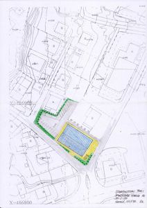 Situasjonsplan som viser tomtens plassering i forhold til nabolaget, med oppriss av den planlagte bygningen (blått/ygult) og omgivelsene (konturer, veier, andre bygninger).