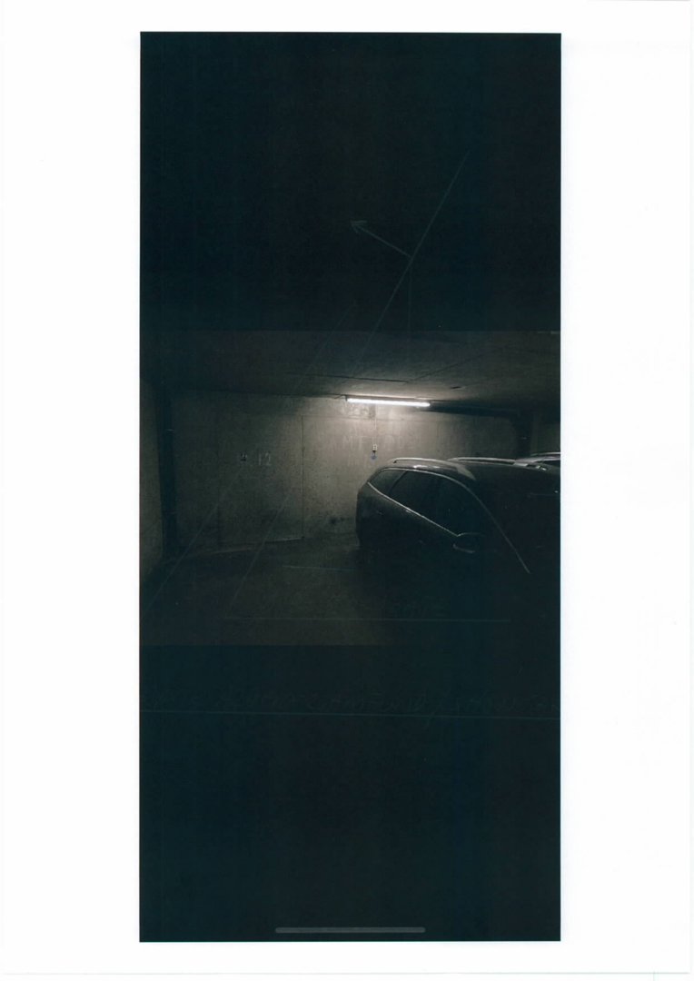 Fotografi av en bil parkert i et underjordisk garasjeanlegg.