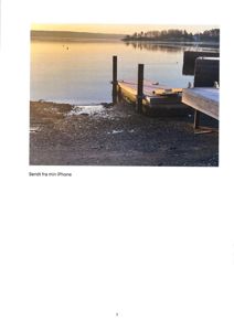 Fotografi av en kai ved vannet med en bygning i bakgrunnen.