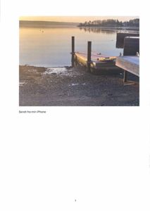 Fotografi av en kai ved vannet med en utsikt over en fjord eller innsjø.