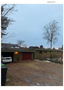 Fotografi av en enebolig med garasje, sett fra fortau eller gate.