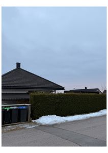 Fotografi av en bolig med tak, hagehegn og snø på bakken.