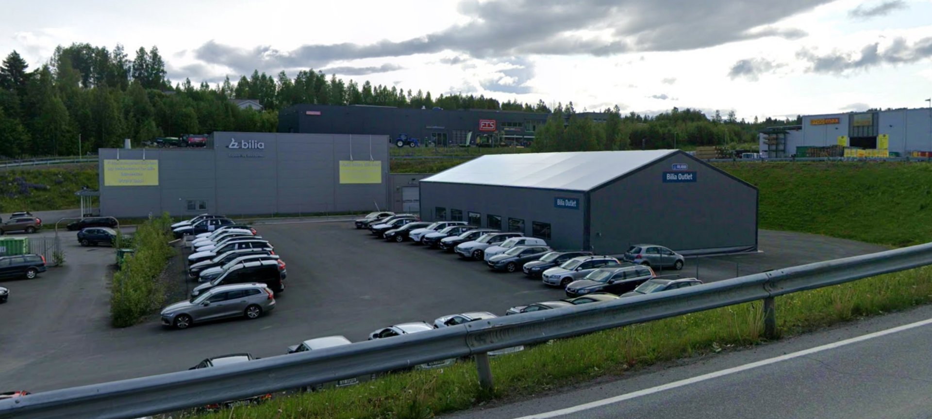 Fotografi av en bilforhandler (Bilia) med flere biler parkert i forhandlerens område.