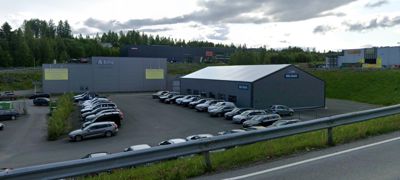 Fotografi av en bilforhandler (Bilia) med flere biler parkert i forhandlerens område.