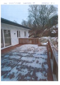 Fotografi av en terrasse med snø, ved et hus. Bildet har håndskrevne notater øverst (saksnr, adresse, vedlegg) og en blå linje med tekst på terrassen.