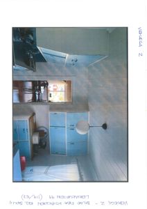 Fotografi av et kjøkken med blå skap og hvite panelvegger