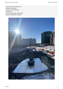 Fotografi av et byggeplassområde med graving, snø og omgivende bebyggelse.