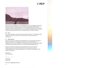 Et fotografi som viser en stor, hvit, bølget takkonstruksjon (sannsynligvis en skole eller lignende) med en bakgrunn av fjell og skog.