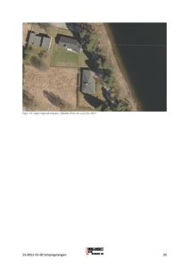 Et luftfoto (fotografi) av en tomt med tre hus og en vannflate.