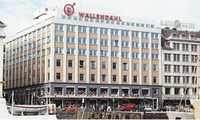 Fotografi av etasjenes fasade med 'WALLEND AHL' skiltet på taket.