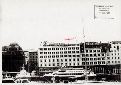 Sort-hvitt fotografi av en bygning (Wallerdals) med båter i forgrunnen. Bildet har et stempel fra 'Kommunalavdeling Byutvikling' og en håndskrevet kommentar.