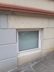 Fotografi av en fasade med et vindu, en vinduskarm og en taklist.