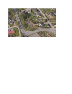 Flyfoto eller satellittbilde som viser et nabolag med hus, veier og grøntområder.