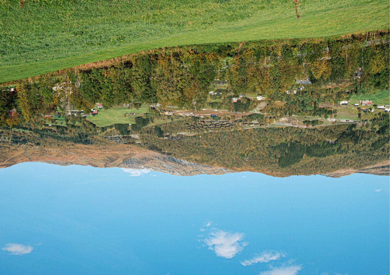 Fotografi av et landskap med fjell, skog og spredt bebyggelse.
