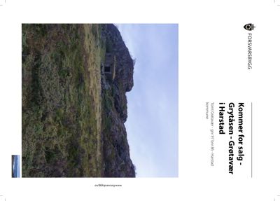 Fotografi av en tomt med en liten bygning på en fjellside.