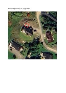 Satellittbilde (flyfoto) fra Google Maps som viser et nabolag med flere hus og en vei. Et rødt rektangel markerer en spesifikk tomt eller bygning.